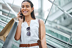 Trendy woman using a cellphone while out on a shopping spree. Female enjoying retail therapy while staying connected with her smartphone. Calling to find a sale and discount. Planning to spend money.