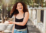 Beautiful young mixed race woman with an afro removing her mask and looking happy. The end of the corona virus pandemic. female looking free and relieved while breathing fresh air outside in the city 