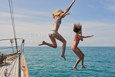 Buy stock photo Excited women jumping from boat to swim in the ocean. Cheerful women jumping from boat during cruise to swim in the ocean.