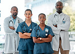 Group of serious diverse doctors standing in a line with their arms crossed while working at a hospital. Focused expert medical professionals at work together at a clinic