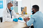 African american doctor talking a patient about his results. Patient in a checkup with a doctor. Dedicated doctor showing his patient his results on a clipboard. GP talking to a patient