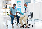 Doctor and patient talking about test results. doctor and patient talking about covid symptom test results. Doctor showing a patient his chart clipboard. Doctor and patient in a clinic
