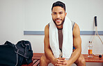 Portrait of a handsome man taking a break after a match. Happy young player sitting in a gym locker room. Fit, young player before a game. Confident young man taking a break in his gym