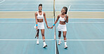 Tennis players holding hands after a match. Two women walking by the net on the tennis court holding hands. Young friends bonding after tennis practice. Happy tennis players on the court