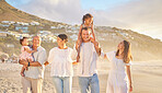 Happy mixed race family of six walking on the beach. Two cute sisters enjoying the sand and sea with their mom, dad, grandmother and grandfather. Grandparents with their kids and grandchildren