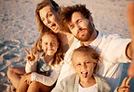 Family taking a selfie on the beach. Carefree family enjoying a holiday by the beach. Happy family taking a photo during vacation on the beach. Parents enjoying a holiday with their little children