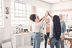 Group of five cheerful diverse businesspeople giving each other a high five in an office at work. Business professionals having fun joining their hands in support and unity during a meeting