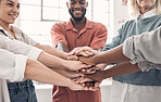 Group of diverse businesspeople piling their hands together in an office at work. Business professionals having fun standing with their hands stacked for motivation and unity