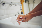 Close up of a woman washing her hands with water without soap over sink in bathroom. Covid-19 coronavirus protective measure
