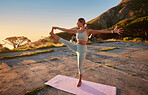 Full length yoga woman holding hand to toe pose in outdoor practice in remote nature. Beautiful caucasian person using mat, balancing while stretching alone at sunset. Young, active, zen and serene