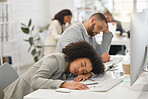 Young mixed race businesspeople sleeping at their desks while working in an office at work. Hispanic business professionals taking a nap while working together
