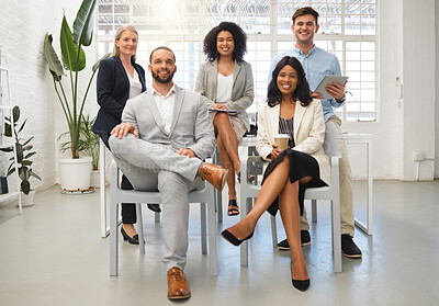 Buy stock photo Portrait of a group of five cheerful diverse businesspeople sitting together at work. Business professionals having a meeting in an office. Colleagues planning together