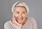 Portrait of one happy caucasian mature woman isolated against a grey sopyspace background. Confident smiling senior woman looking cheerful while showing her natural looking teeth in a studio