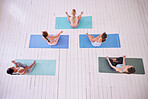 group of women sitting in lotus pose from above. Women in yoga class sitting on the floor. Peaceful women in yoga posture sitting on mats. Women relaxing in yoga class together from above