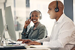 Portrait of happy young african american call centre telemarketing agent talking on a headset while working on a computer in an office alongside a colleague. Confident friendly female consultant operating helpdesk for customer service and sales support