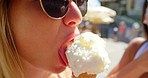 A young woman enjoying an ice cream cone with her friend while on holiday in Italy