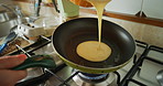 A woman mixing a bowl of pancake batter before cooking a pancake in the pan