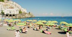 A crowd of people sunbathing on a beach in Italy. A blurred crowd of people spending the day on the beach