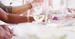 Closeup of diverse group of friends or family eating feast and drinking wine during lunch party in restaurant or home. Hands of men and women dishing food servings while socializing and enjoying meal